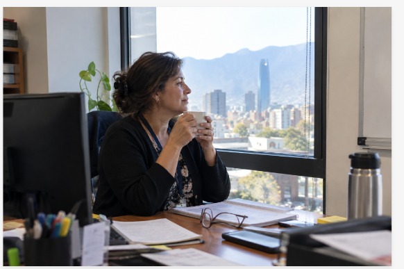 Trabajadora hace una pausa junto a la ventana de su oficina