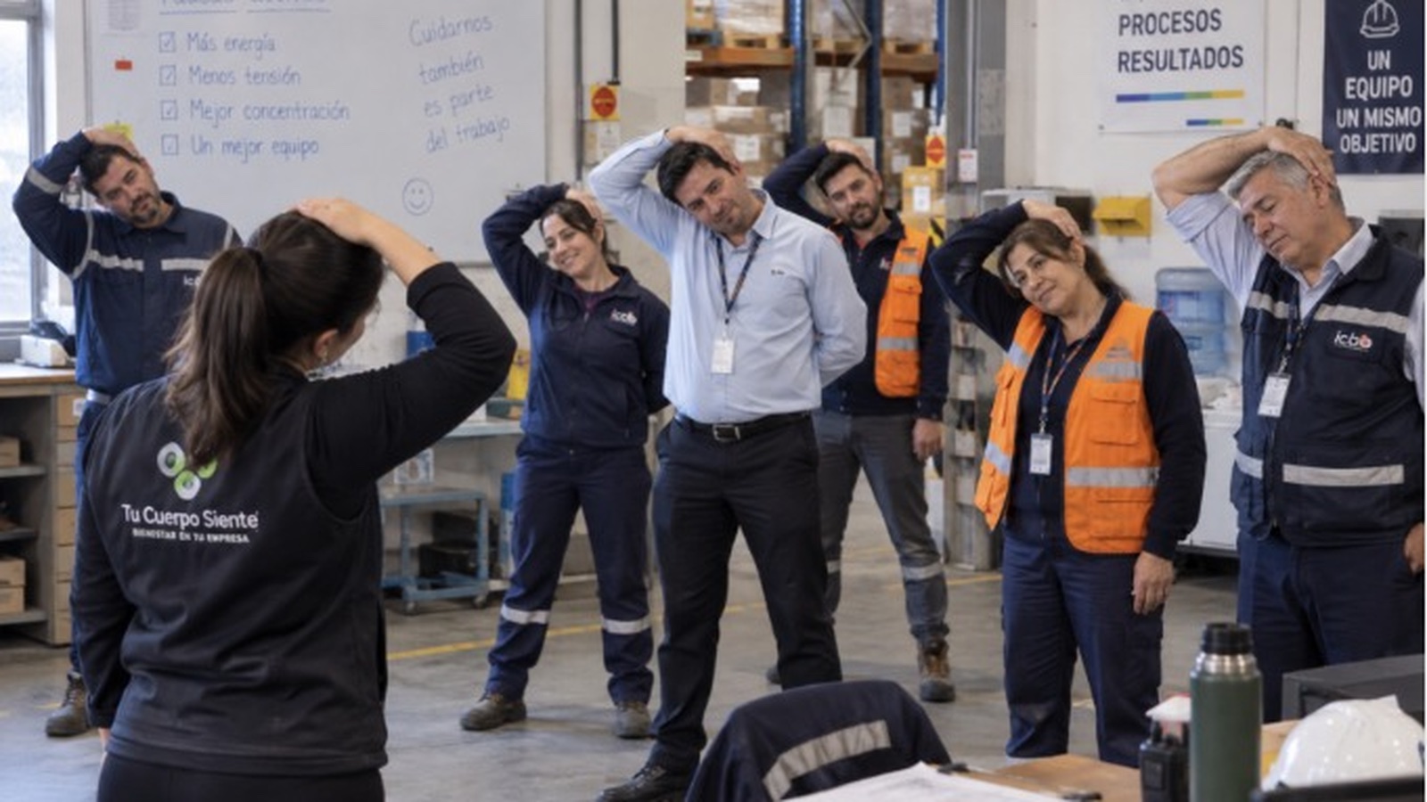 Trabajadores de distintos turnos realizan estiramientos guiados en su lugar de trabajo